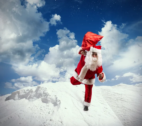 Papai Noel com brindes saco corre — Fotografia de Stock