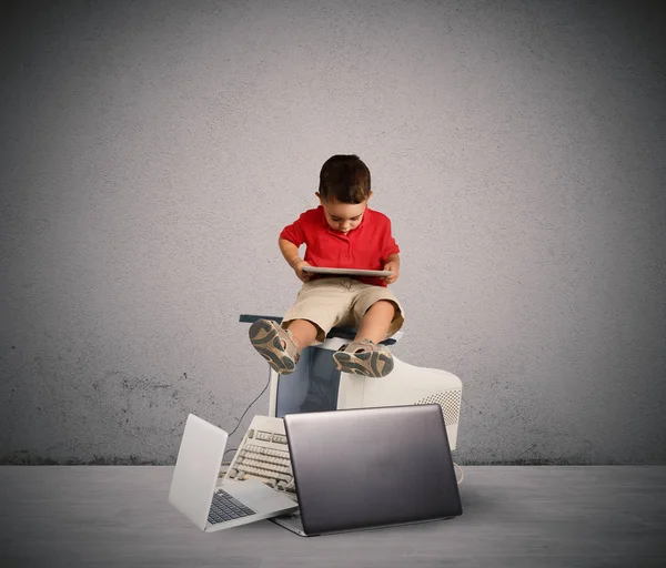 Niño sentado en una pila de computadoras . —  Fotos de Stock