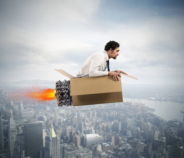 Businessman flying with a cardboard missile — Stock Photo, Image