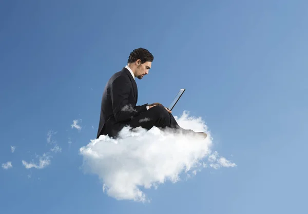 Uomo d'affari con laptop su cloud — Foto Stock