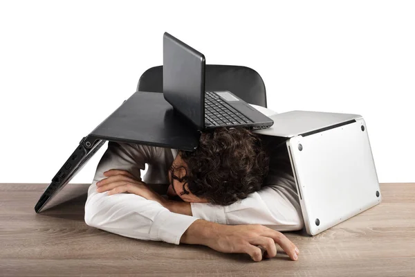 Бизнесмен спит под грудой компьютеров — стоковое фото