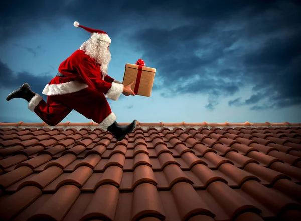 Santa Claus corre con un gran regalo — Foto de Stock