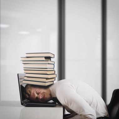 İşadamı bir yığın kitap ile laptop