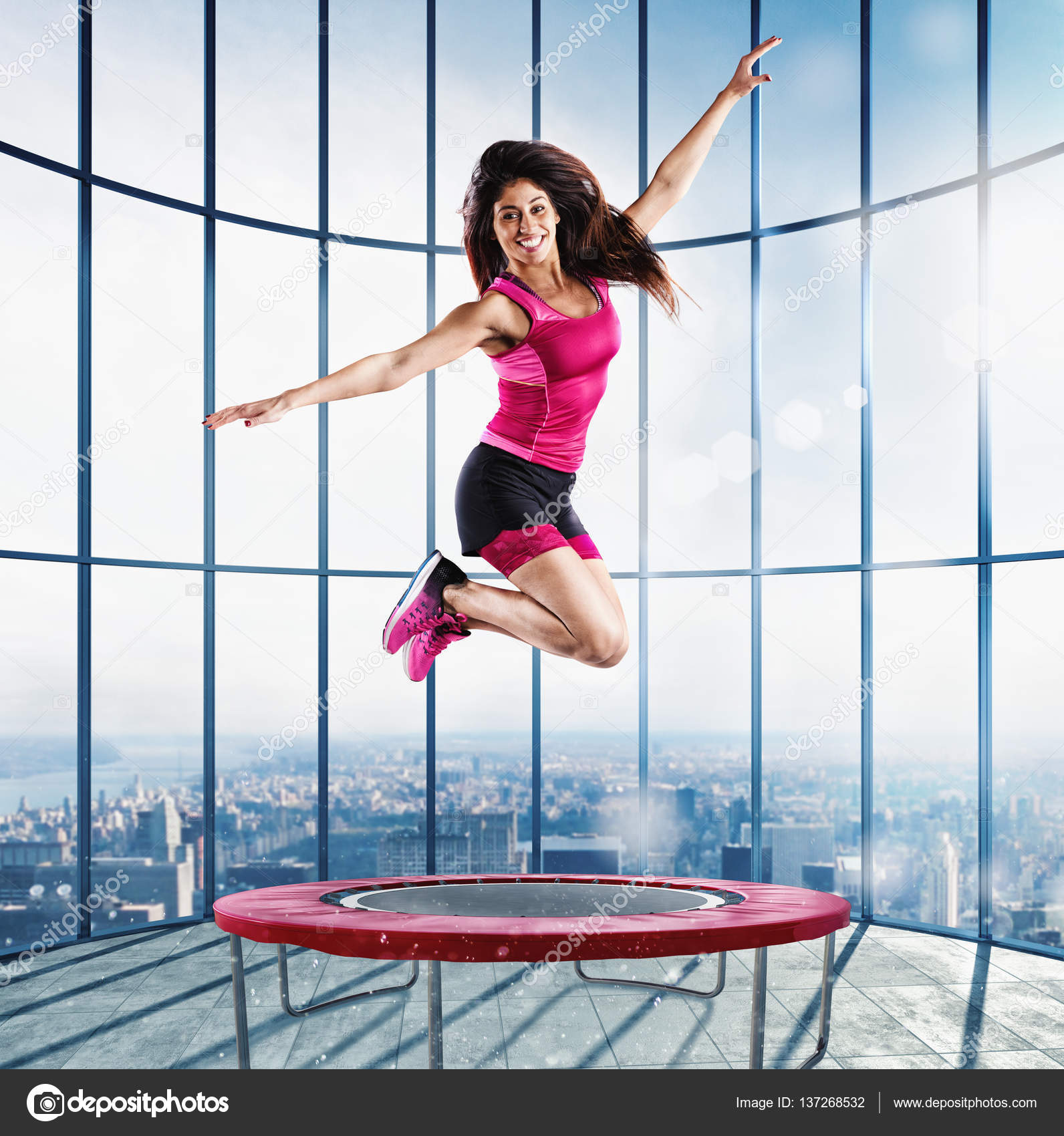 Mujer joven fitness en ropa deportiva saltando en un trampolín