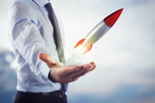 Businessman holding a small rocket — Stock Photo, Image
