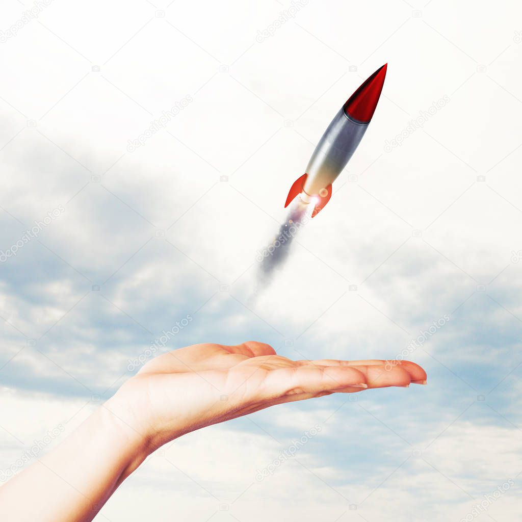 Businesswoman holding a small rocket