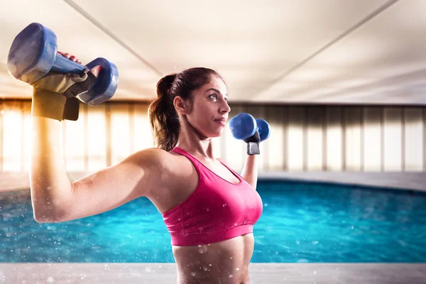Mujer muscular está entrenando con pesas —  Fotos de Stock