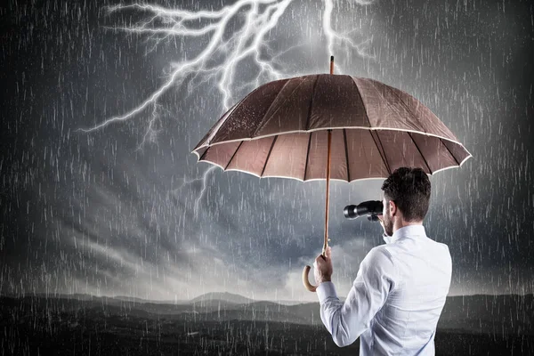 Geschäftsmann mit Regenschirm geschützt — Stockfoto