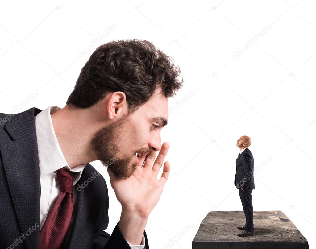 Businessman speaks  to a small man.