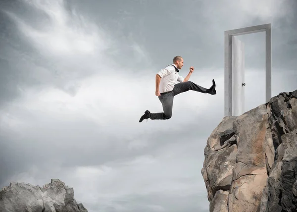 Бизнесмен прыгает через горы — стоковое фото