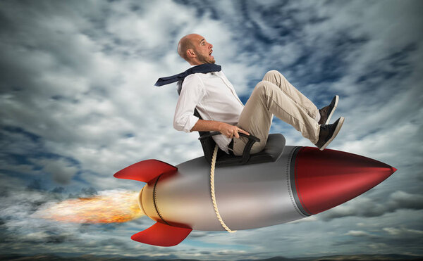 Бизнесмен, летящий над ракетой
