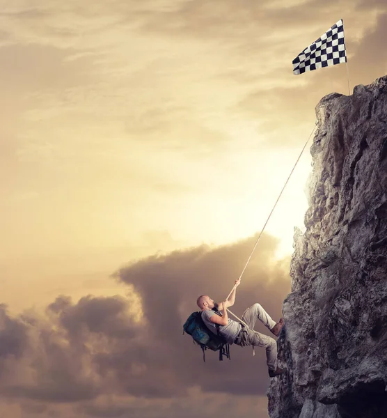 Empresario escalando una montaña con una cuerda — Foto de Stock