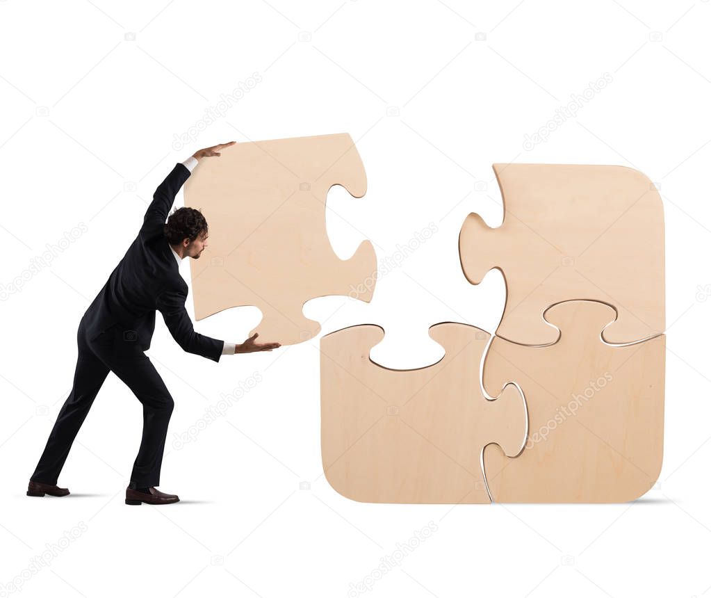 Businessman complete a big puzzle