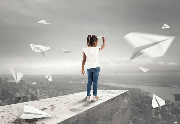 Little girl throws paper airplanes — Stock Photo, Image