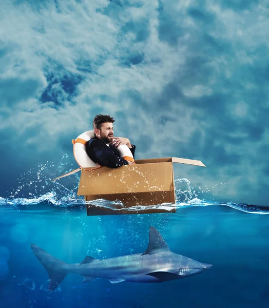 Geschäftsmann auf einem Karton im Meer — Stockfoto