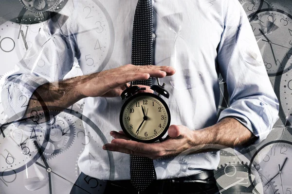 Businessman holds an alarm clock. — Stock Photo, Image