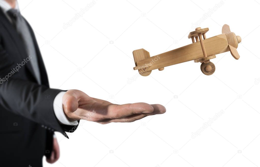 Businessman holding a small wooden aircraft