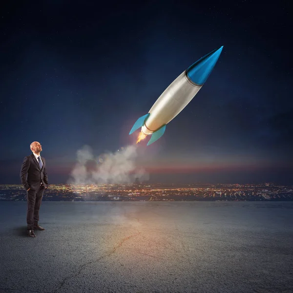 Бизнесмен рассматривает запуск ракеты — стоковое фото