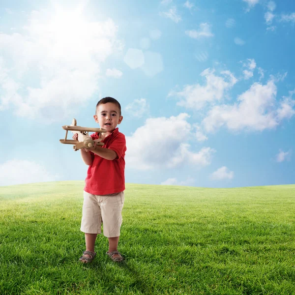 Kind speelt met een houten vliegtuig — Stockfoto