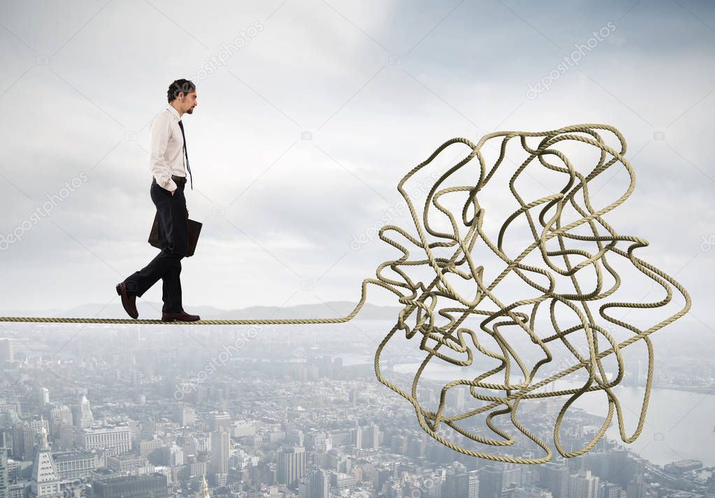  businessman walking  on a tangled rope