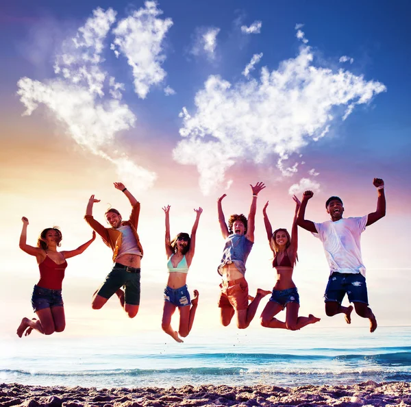 Felices amigos sonrientes saltando sobre un cielo azul con un mapa del mundo hecho de nubes — Foto de Stock