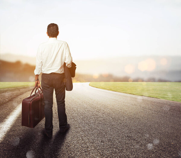 Man walking  on a road with his suitcase 