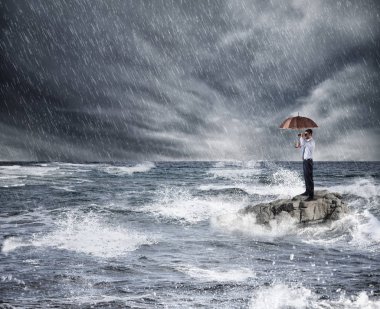 Businessman with umbrella during storm