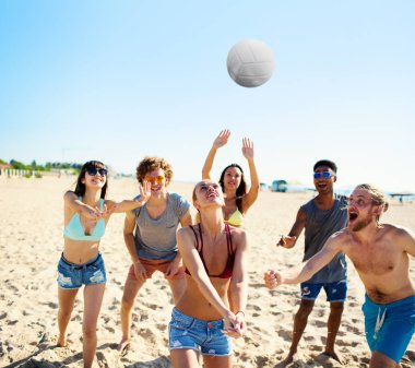 Plaj voleybolu kumsalda oynarken arkadaş grubu