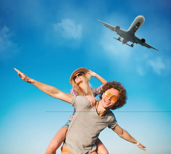 Happy smiling couples playing at the beach with aircraft in the sky — Stock Photo, Image