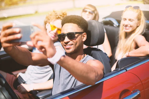 Jovens amigos tiram uma selfie em um carro cabriolet — Fotografia de Stock
