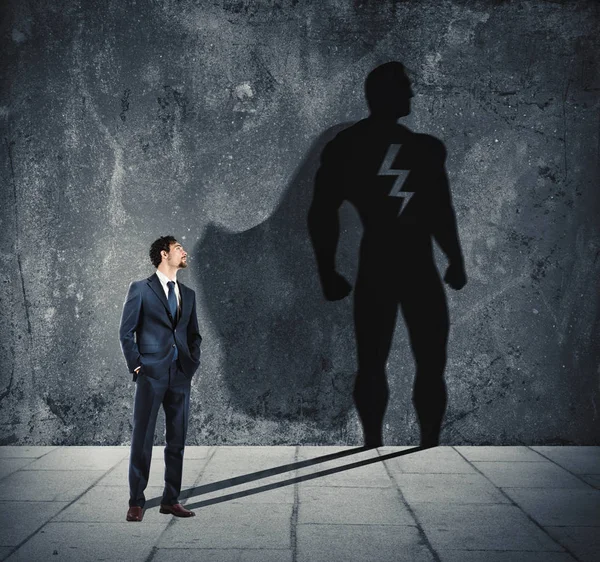 Бизнесмен со своей тенью супергероя — стоковое фото