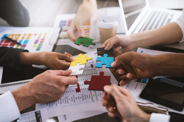 Ondernemers bouwen een gekleurde puzzel. — Stockfoto