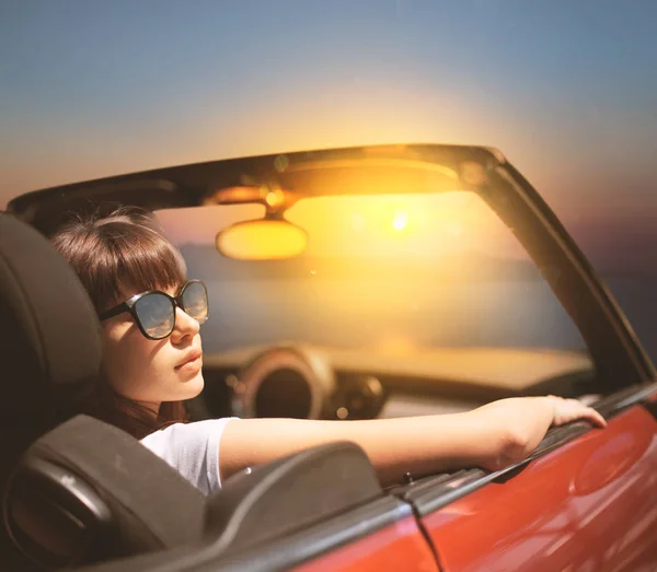 Mujer joven en coche cabriolet cerca del mar — Foto de Stock