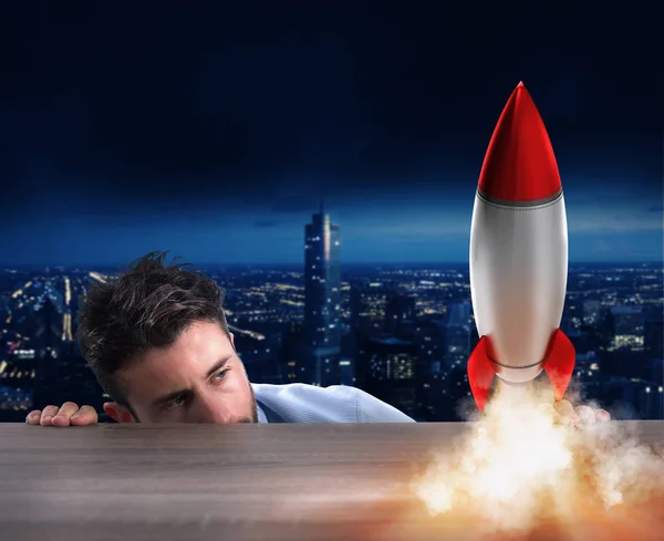 Businessman looking at  small rocket. — Stock Photo, Image