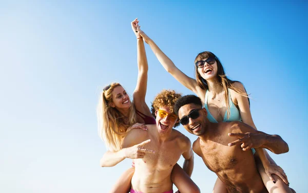 Happy smiling couples playing at the beach — Stock Photo, Image