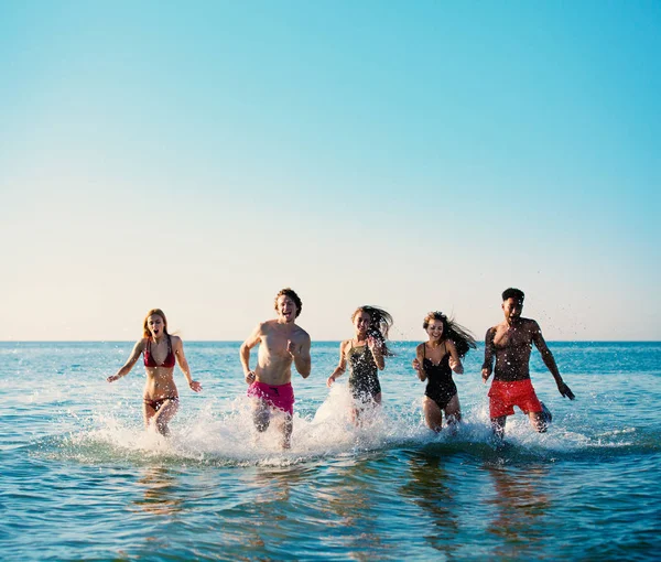 Un groupe d'amis court dans la mer. Concept d'été — Photo