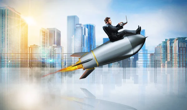 Hombre de negocios con portátil sobre cohete — Foto de Stock