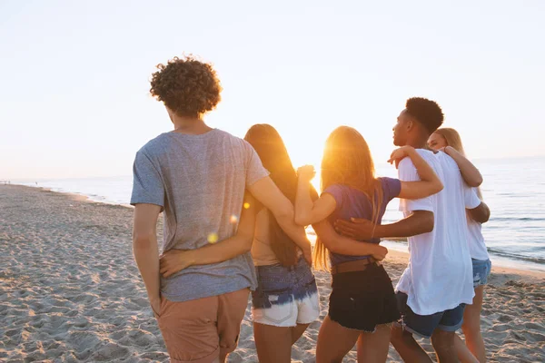 Groep gelukkige vrienden plezier in ocean beach — Stockfoto