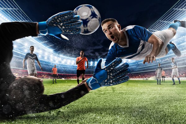 Вратарь ловит мяч на стадионе.
