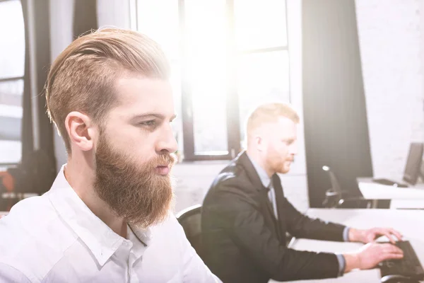 Empresario en la oficina trabajando con un ordenador con su equipo — Foto de Stock