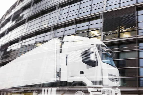 Schneller weißer LKW spiegelt sich auf einem Wolkenkratzer. — Stockfoto