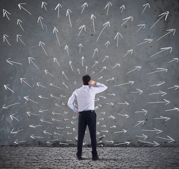 Hombre Negocios Confuso Mirando Una Pared Con Flechas Direccionales Concepto — Foto de Stock