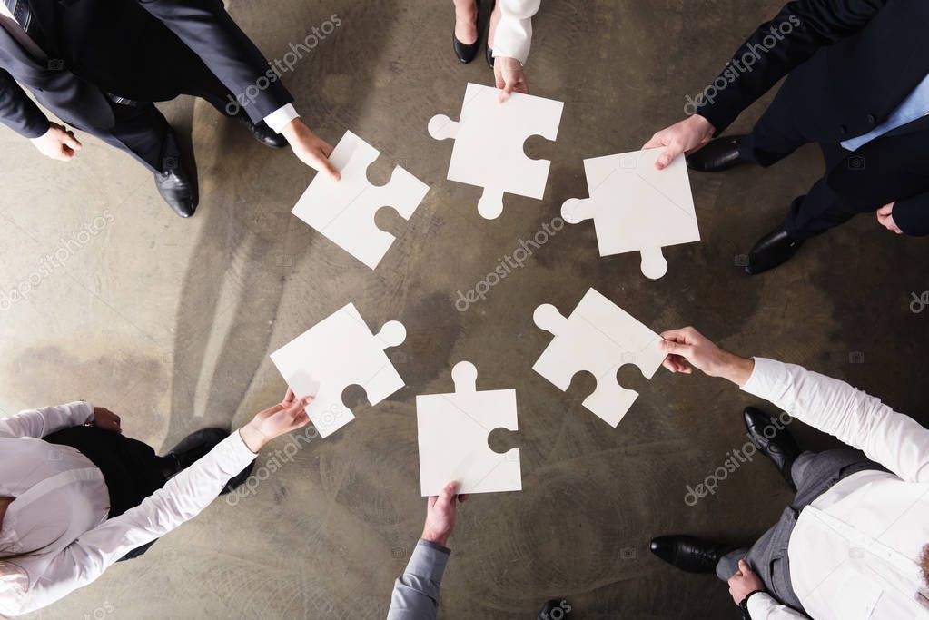Business people  working together to build a big puzzle. Concept of teamwork, partnership, integration and startup.