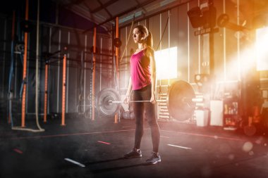 Spor salonunda bir halter ile çalışma dışarı kararlı atletik kız