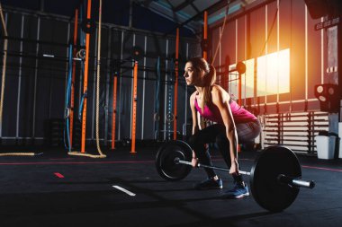 Spor salonunda bir halter ile çalışma dışarı kararlı atletik kız