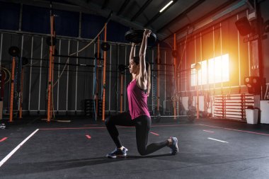 Halter disk ile spor salonunda egzersiz kararlı atletik kız