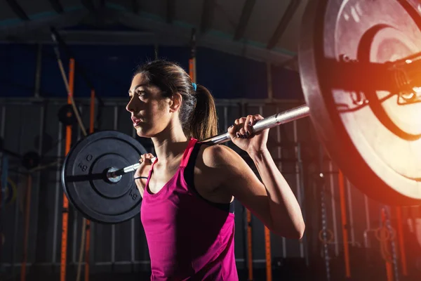 坚定的运动女孩在健身房锻炼与杠铃 — 图库照片