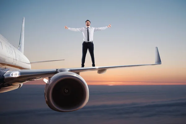 Un homme d'affaires sur une balançoire d'avion. Concept de liberté — Photo