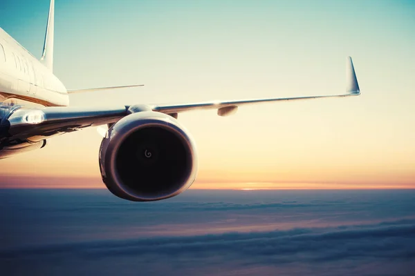 Aircraft flight over the clouds during sunrise — Stock Photo, Image