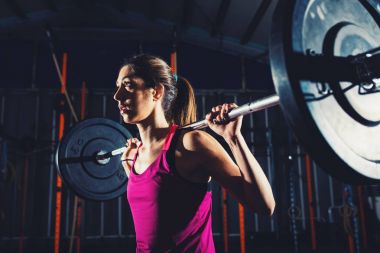 Spor salonunda bir halter ile atletik kız inşaat dışarı